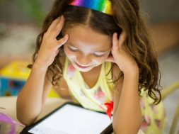 young girl smiling at an iPad-2