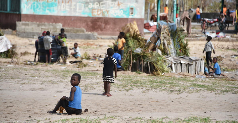 Image of makeshift shelters and children sitting on the ground. Image: World Vision