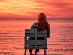 Woman-sitting-on-beach-at-sunrise.jpg