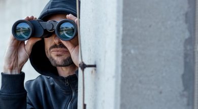 A-man-in-dark-hoodie-with-binoculars.jpg