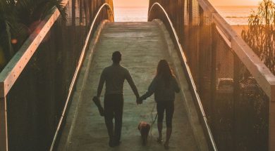 Couple-walking-dog-near-beach.jpg